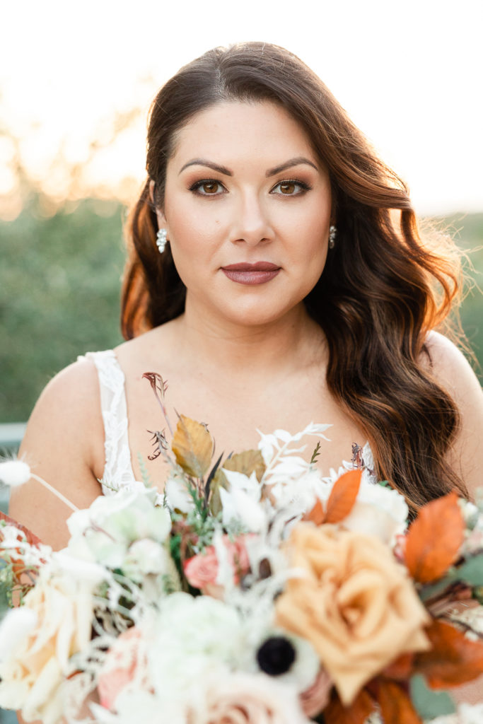 A sunset portrait of a bride at the greenhouse at driftwood, one of the best austin wedding venues. 