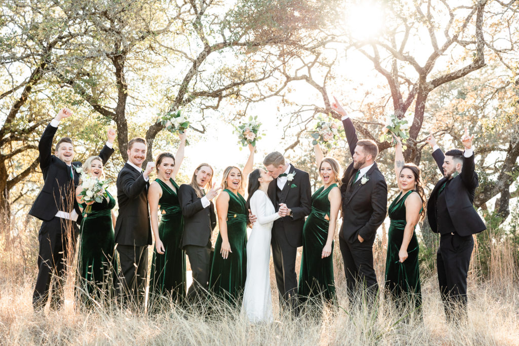 A laughing and cheering wedding party at Mae's Ridge, one of the best austin wedding venues