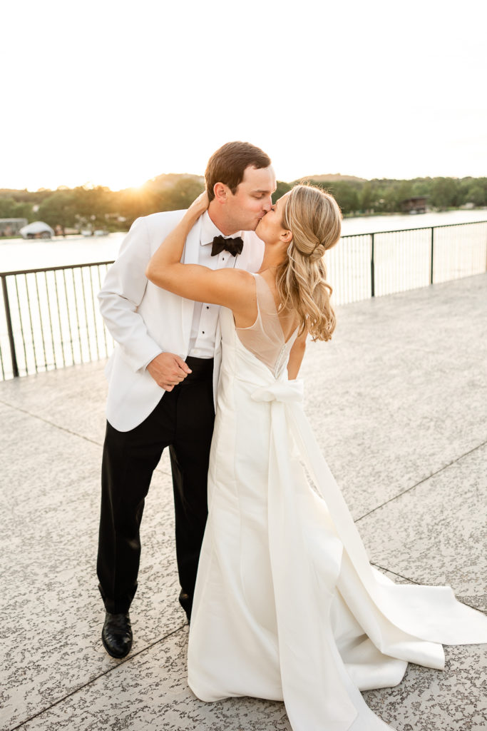 A sunset portrait of a bride and groom kissing at Westwood Country Club, one of the top austin wedding venues. 