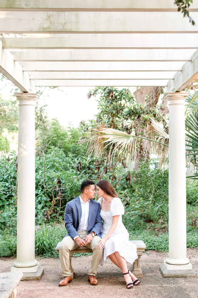 Engagement photo of a couple, the groom wearing a blue blazer, the bride wearing a white dress.  